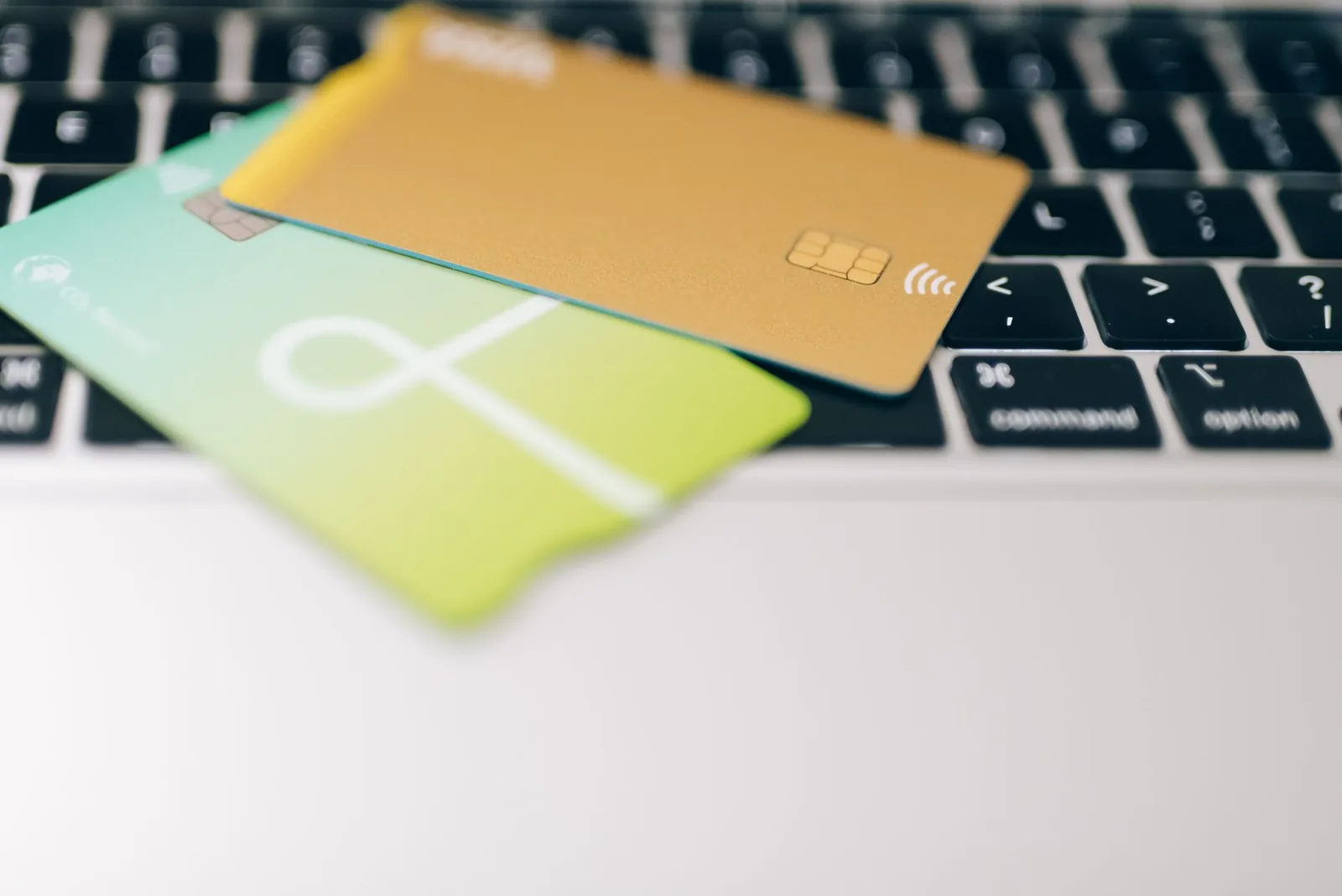 Two payment cards resting on a laptop keyboard